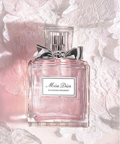 Miss Dior Blooming Bouquet perfume bottle on a textured pink background