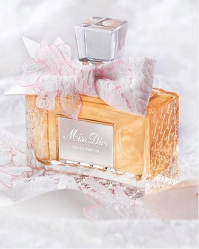 Miss Dior eau de parfum bottle with decorative bow on a white background
