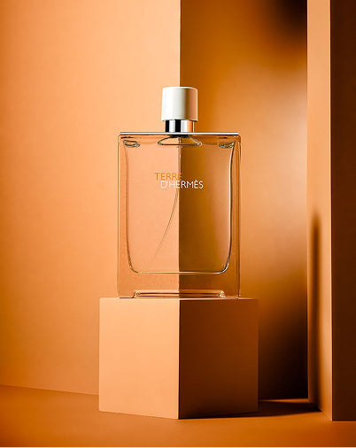 Perfume bottle with 'Hermes' branding on an orange background