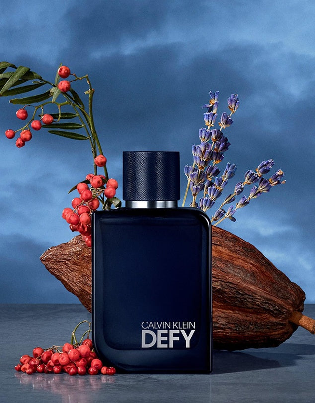 Calvin Klein Defy perfume bottle with decorative elements on a blue background