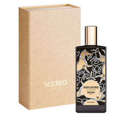 A bottle of MEMO PARIS Irish Leather Eau de Parfum next to its kraft paper packaging box, on a solid white background.